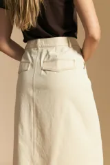 Falda larga de mezclilla color crema, de corte recto y talle alto, con costuras visibles en contraste y abertura frontal.