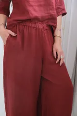 Pantalón de lino color bordó, de corte palazzo y cintura elástica.