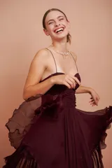 Vestido corto color vino de seda con escote corazón, breteles finos y falda con volados.