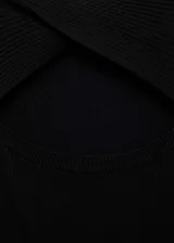Vestido midi negro de punto, entallado, con cuello redondo, mangas cortas y abertura en la parte delantera. Diseño reversible.