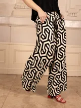 Pantalón palazzo estampado geométrico en blanco y negro, de corte amplio y tiro alto.