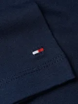 Vestido azul marino de algodón orgánico, corte recto, largo a la rodilla, cuello redondo, mangas cortas y cintura ajustable con cordón. Logo de Tommy Hilfiger bordado en el pecho y en la manga.