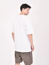 Remera celeste de corte oversized con estampado frontal con la palabra 'Stuck' y una frase en inglés.