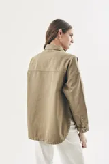 Sobrecamisa de denim color crudo, de corte oversize con hombros caídos, mangas largas y bolsillos delanteros.