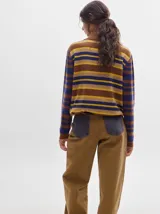 Cardigan de algodón con estampado de rombos en tonos marrón, beige y azul. Tiene cuello camisero, cierre frontal con botones azules y calce suelto.