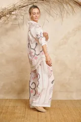Conjunto de camisa de manga larga con cuello y pantalón palazzo, ambos con estampado de flores y hojas en tonos rosa, gris y marrón sobre fondo blanco.