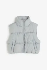 Chaleco puffer corto color gris con cuello alto, cierre frontal y bolsillos laterales.