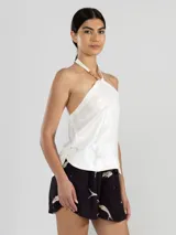 Top halter blanco de lino italiano con hilo metalizado y insignia de tigre removible.