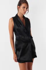 Minivestido blanco tipo blazer sin mangas, con cuello solapa, doble botonadura cruzada, bolsillos ojal y tira de ajuste en la espalda.