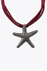 Collar de cordón doble color borgoña con dije metálico en forma de estrella de mar plateada con incrustaciones de strass.