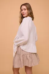 Minifalda color beige con textura arrugada, cintura elastizada y volado en el ruedo.