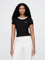 Remera negra de algodón con cuello redondo blanco y logo de Gap bordado en el pecho.