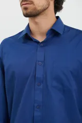Camisa de corte sport color azul oscuro, con bolsillo frontal y puños ajustables.