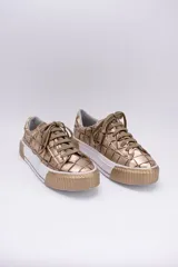 Zapatillas bajas color dorado con diseño trenzado, cordones y suela de goma.