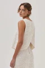 Top de lentejuelas color blanco, sin mangas y con espalda cruzada.