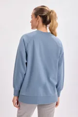 Buzo deportivo celeste con cuello redondo y mangas largas. Estampa frontal con la frase "Self Love Club, do not disturb" en letras blancas. Corte oversize con aberturas laterales.