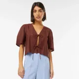 Blusa marrón con escote en V, mangas cortas y lazos para atar en el frente.