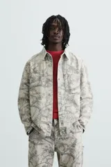 Sobrecamisa relaxed fit de algodón con cuello solapa, manga larga con puños abotonados, bolsillos de plastrón en el pecho, efecto lavado y cierre frontal abotonado. Estampado abstracto en tonos grises.