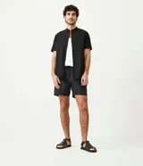 Camisa negra de algodón con corte slim, cuello mao, manga corta y abotonadura frontal.