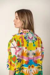 Camisa color crema con estampado de palmeras rosas, de corte recto y manga corta.