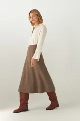 Falda midi evasé color beige, tejida en lana fina con detalle de pespuntes y cierre oculto.