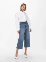 Pantalón de jean celeste, de tiro alto, corte wide leg y largo cropped.