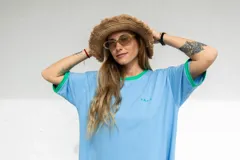 Vestido celeste con cuello redondo y mangas cortas con ribete verde. Estampado pequeño con letras en el pecho.