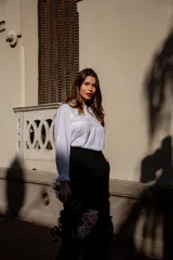 Camisa color crema con cuello alto y mangas largas con volados en los puños. Presenta detalles de crochet y broderie en el frente.