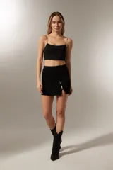 Top cropped blanco de nylon, liso y al cuerpo con tirantes finos.