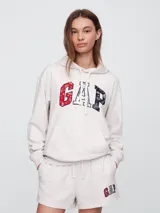 Buzo canguro de mujer, marca Gap, color rosa claro, con capucha y logo estampado en el frente.