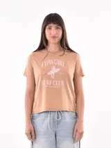 Remera color tostado con estampa frontal que incluye texto y dibujo de una surfista.