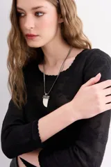 Collar con cadena plateada tipo víbora y dije con forma de cuerno color hueso con detalles metálicos plateados.