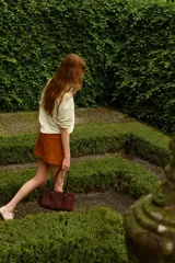 Minifalda marrón de corte evasé, con acabado cepillado suave y costuras decorativas adelante y atrás. Tiene cierre y pretina prolongada con botón a presión.