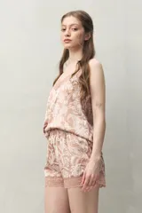 Short de pijama rosado con estampado floral blanco y encaje rosado en el borde inferior. Confeccionado en tejido satinado con cintura elastizada.