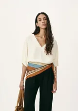 Blusa color crema con escote en V y mangas cortas amplias.