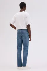 Pantalón de jean azul de corte recto, con cinco bolsillos y cierre con botón y cremallera.