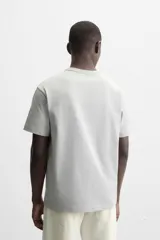 Camiseta negra de algodón de corte regular, con cuello redondo con ribete doble y mangas cortas.