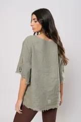 Blusa verde oliva de lino con cuello redondo, mangas cortas amplias con flecos, cierre lateral con botones y ruedo con flecos.