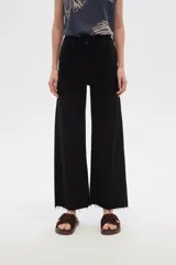 Pantalón de jean color beige, de corte flare y tiro alto, con terminación desflecada.