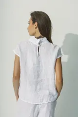 Blusa negra de lino con cuello alto y mangas cortas con detalle de calado en los hombros.