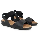 Sandalia casual de cuero color negro con suela color caramelo. Cuenta con una tira ancha de cuero con perforaciones en la parte delantera y una tira elástica en el tobillo para mayor ajuste.