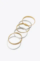 Set de pulseras rígidas doradas y plateadas con diferentes diseños labrados.