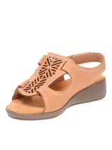 Sandalias bajas color tostado, con diseño calado en el empeine, ajuste con velcro y suela de goma.
