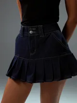 Minifalda de jean azul oscuro con cintura alta, cierre con doble botón y falda plisada.