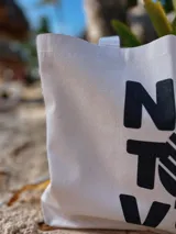 Bolso tipo tote bag de lona color crudo, con asas cortas y estampado frontal con el logo de la marca Nativo en negro.