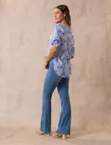 Blusa de gasa estampada azul con diseño paisley, marca Ruby Rd. Cuello a la base, escote en v y abertura con botones. Delantera con bolsillos. Largo de manga regulable con presilla y botón. Terminación de ruedo con nudo.