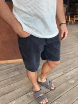 Bermuda de jean negro gastado, corte a la rodilla y estilo slouchy.