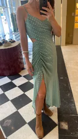Vestido largo verde agua con estampado de lunares, escote corazón, breteles finos y falda con frunces y tajo lateral.