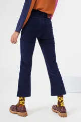 Pantalón de pana azul de tiro alto con silueta levemente acampanada desde la rodilla, con cierre y botón metálico.