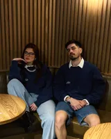 Buzo azul marino de corte clásico con cuello redondo, puños y cintura acanalados. Presenta un bolsillo cuadrado en el pecho y logo de la marca bordado en blanco.